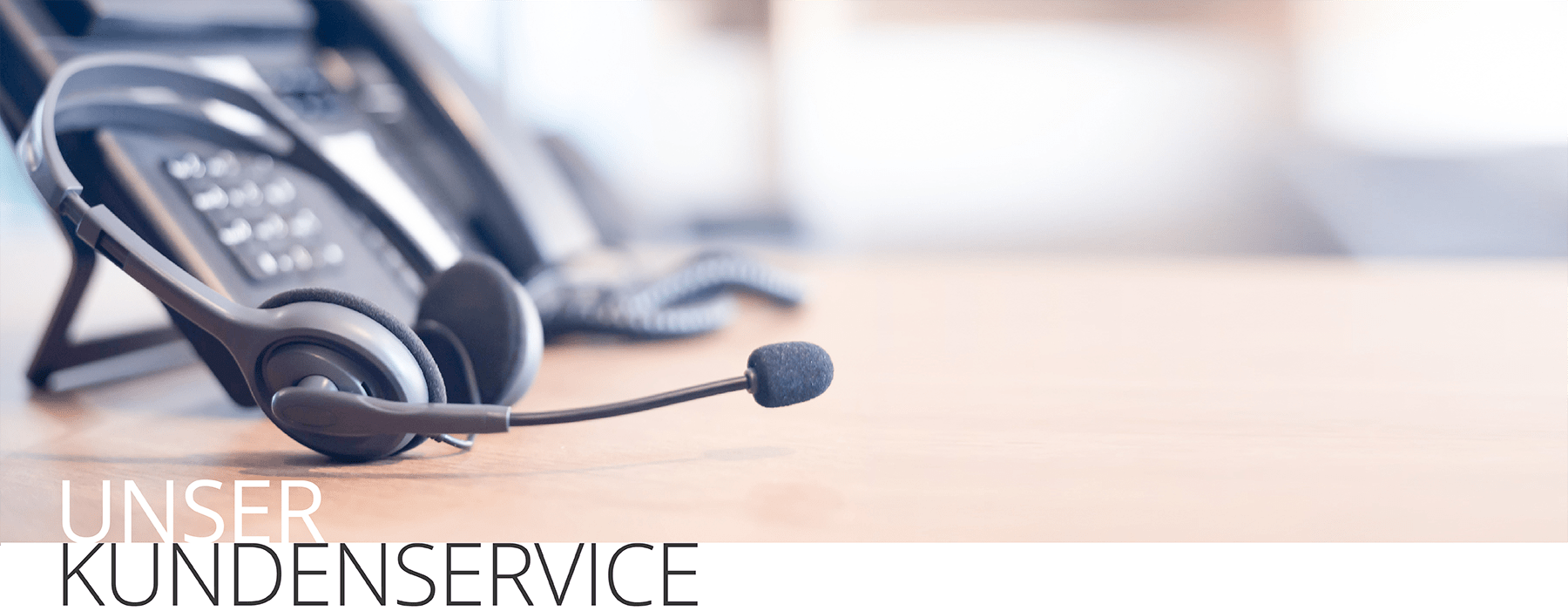 Headset vor mehreren Telefonen auf einem Schreibtisch mit dem Text 'Unser Kundenservice'