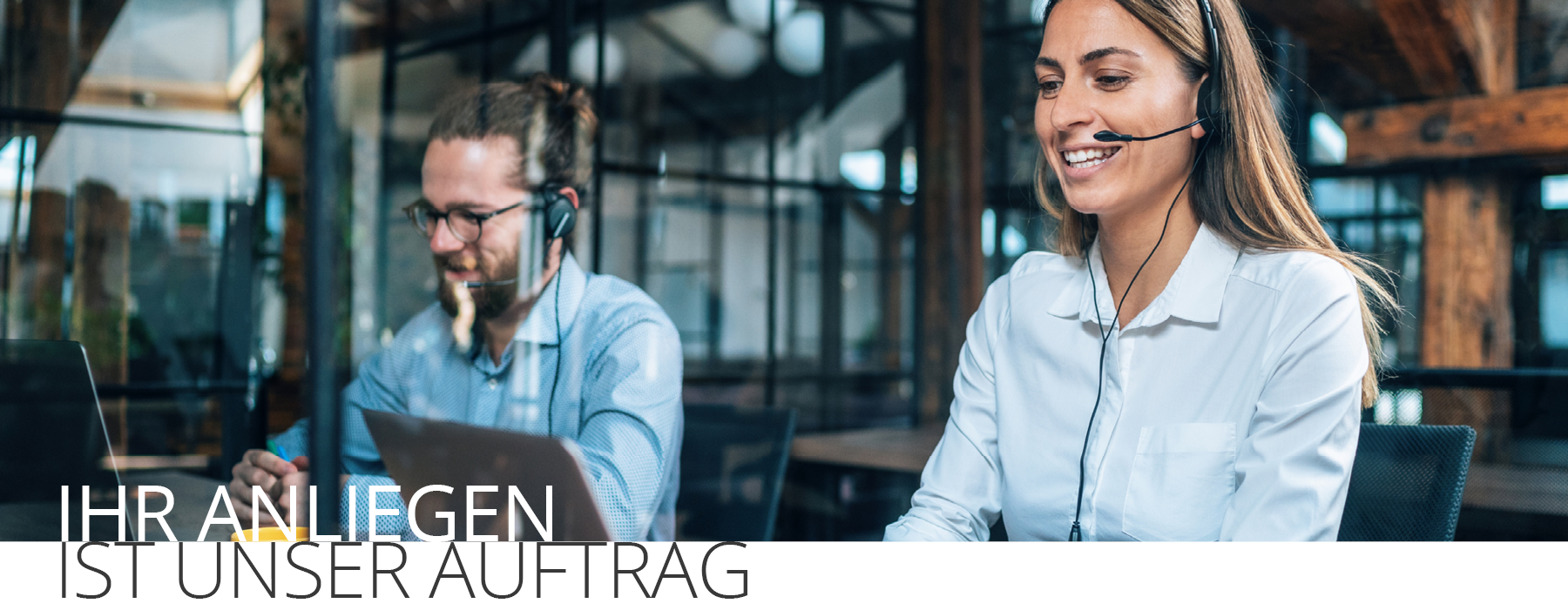 Zwei Service-Mitarbeiter mit Headsets, Text 'IHR ANLIEGEN IST UNSER AUFTRAG'